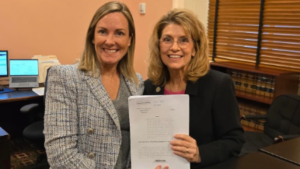 Ohio House Reps. Baker and Gross smiling and holding HB 508